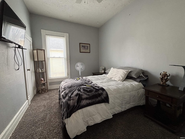 bedroom with ceiling fan, carpet flooring, and a textured ceiling