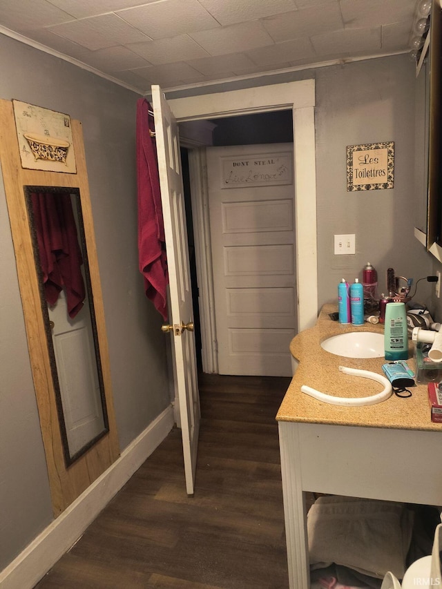 bathroom with ornamental molding, wood-type flooring, and sink