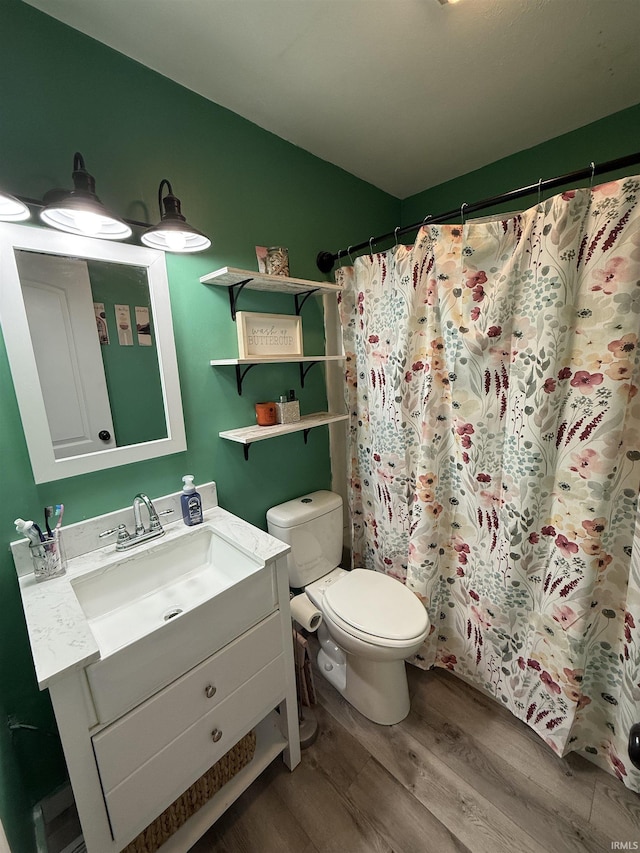 bathroom with vanity, hardwood / wood-style flooring, toilet, and walk in shower