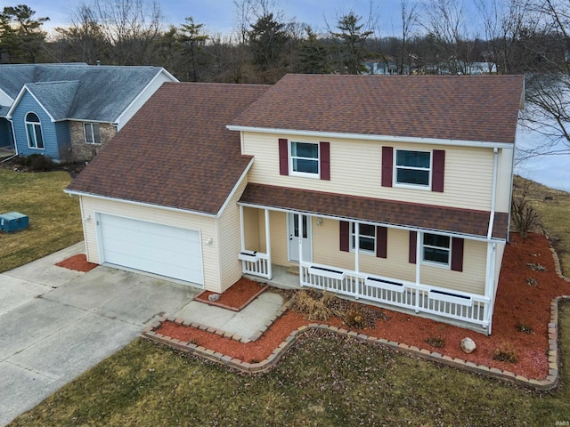 view of front of property with a porch, a garage, and a front lawn