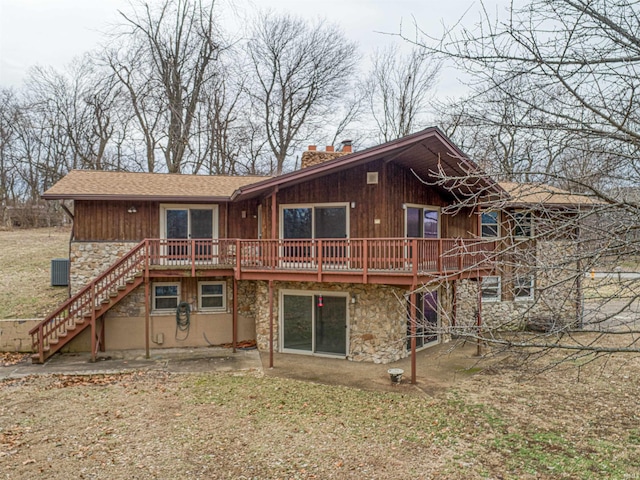 back of property featuring a deck and a patio