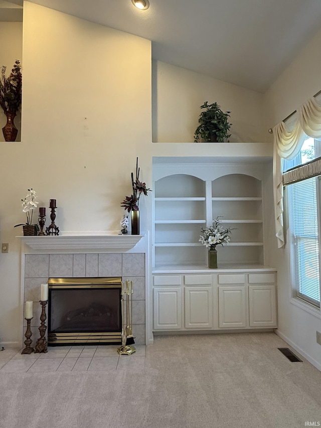 carpeted living room featuring built in shelves and a fireplace