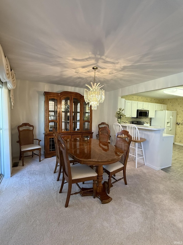 dining space featuring light colored carpet and a chandelier