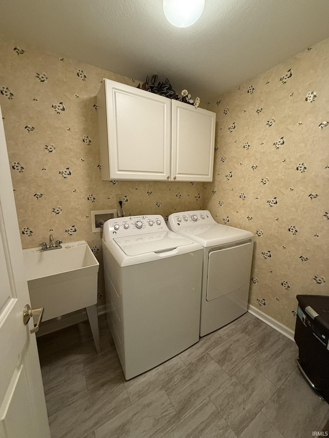 laundry area featuring separate washer and dryer, sink, and cabinets