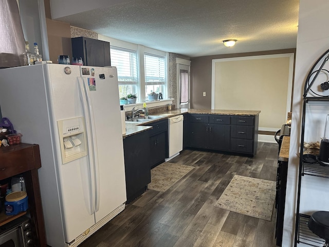 kitchen featuring dark hardwood / wood-style floors, sink, a textured ceiling, and white appliances