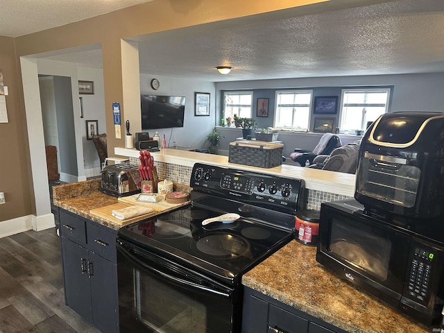 kitchen with plenty of natural light, dark hardwood / wood-style floors, a textured ceiling, and black appliances