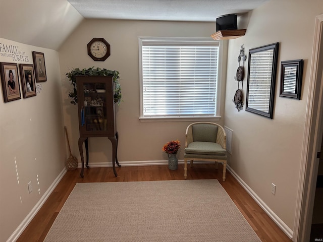 sitting room featuring hardwood / wood-style flooring and vaulted ceiling