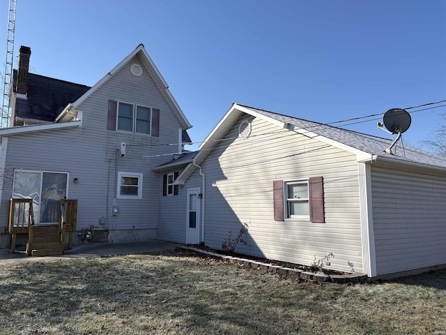 back of house featuring a patio area and a lawn