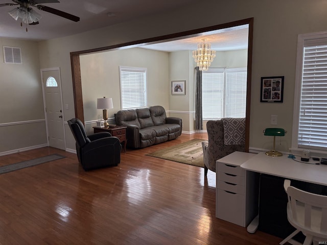 living room featuring hardwood / wood-style flooring, ceiling fan with notable chandelier, and a healthy amount of sunlight