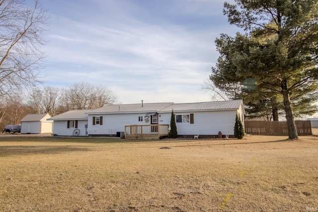 view of front facade with a wooden deck and a front lawn