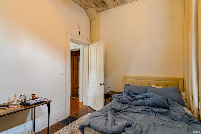 bedroom featuring wood ceiling, dark hardwood / wood-style floors, and a high ceiling