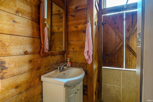 bathroom featuring vanity and wood walls