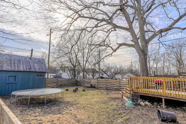 view of yard featuring a wooden deck and a trampoline