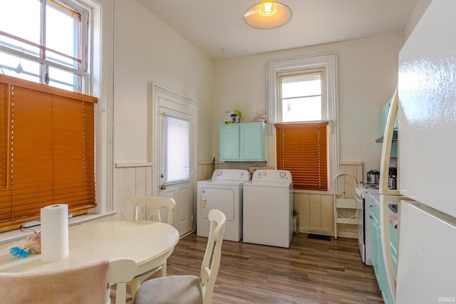 laundry area featuring dark hardwood / wood-style floors, washing machine and dryer, and cabinets