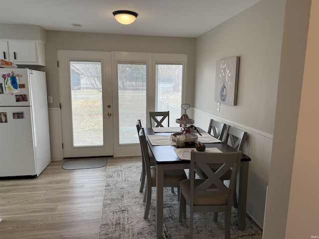 dining space with light hardwood / wood-style flooring, plenty of natural light, and french doors