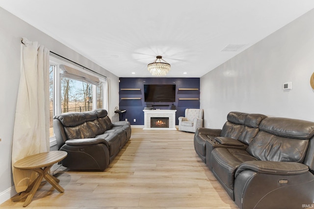 living room with a notable chandelier and light hardwood / wood-style flooring