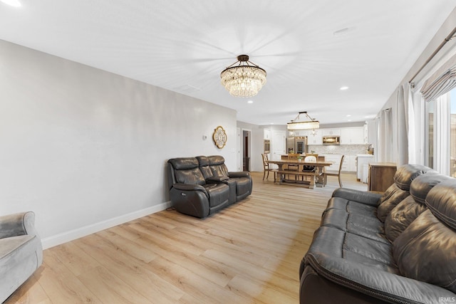 living room featuring a chandelier and light wood-type flooring