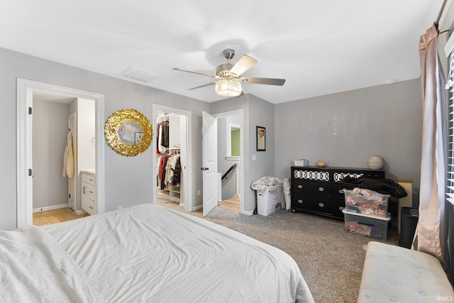 bedroom featuring ceiling fan, a spacious closet, light carpet, and a closet