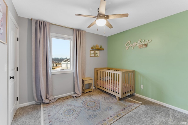 unfurnished bedroom featuring carpet floors, a nursery area, and ceiling fan