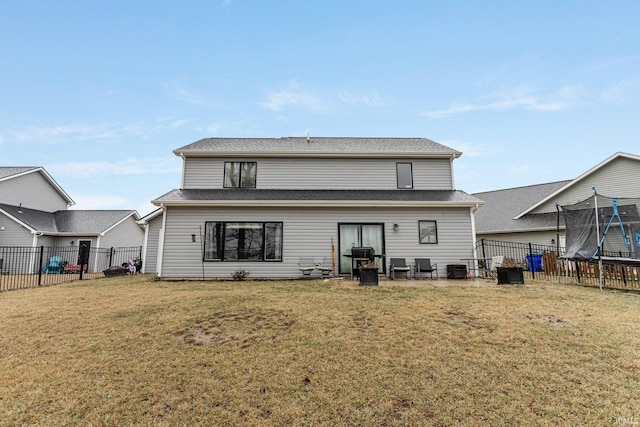 back of property featuring a yard, a trampoline, and a patio area