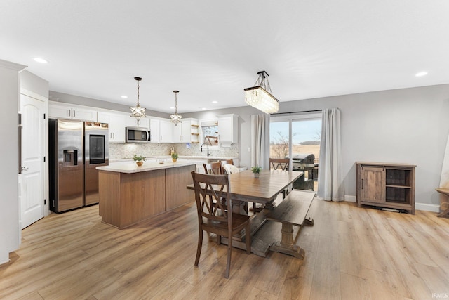 dining room featuring sink and light wood-type flooring