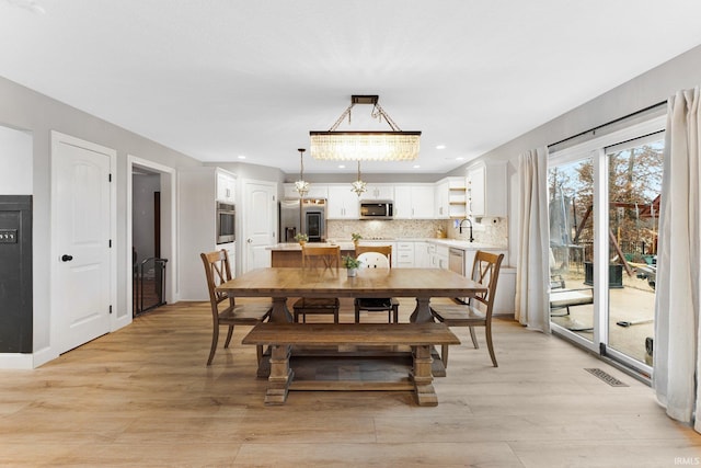 dining space with sink and light hardwood / wood-style floors