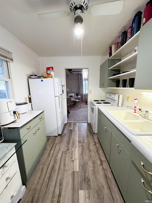 kitchen featuring sink, white appliances, light hardwood / wood-style flooring, and ceiling fan