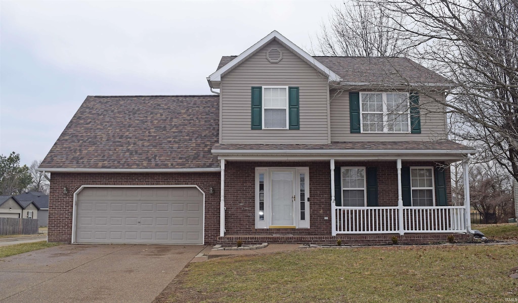 view of front of house featuring a garage, a front yard, and a porch