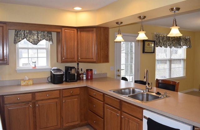 kitchen featuring a healthy amount of sunlight, sink, pendant lighting, and kitchen peninsula