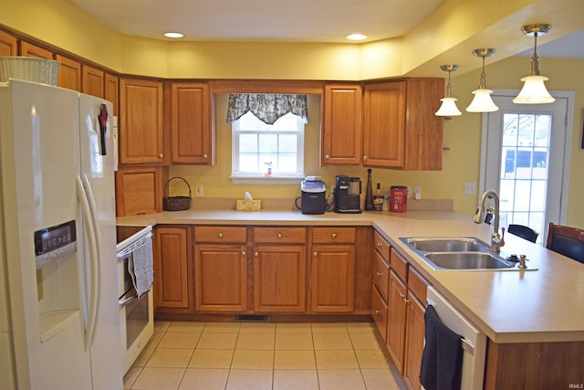 kitchen featuring decorative light fixtures, sink, kitchen peninsula, plenty of natural light, and white appliances