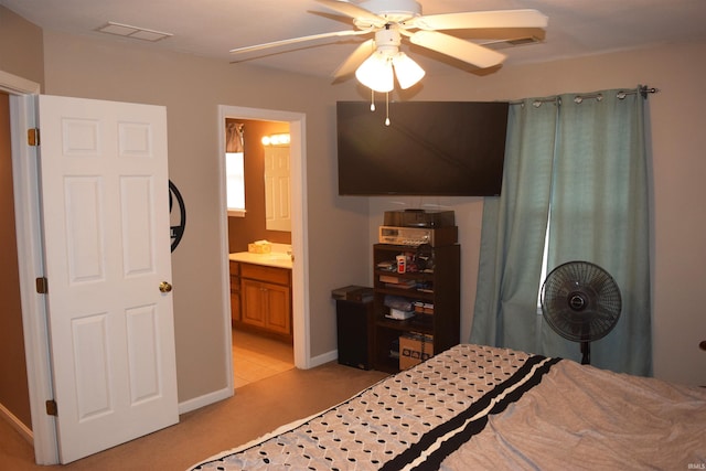 bedroom featuring ceiling fan, ensuite bathroom, and light carpet