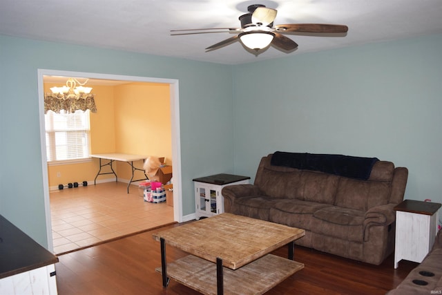 living room with dark wood-type flooring and ceiling fan with notable chandelier