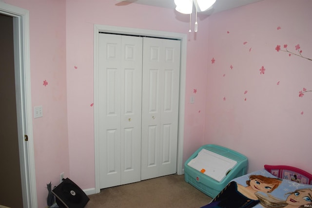 carpeted bedroom with ceiling fan and a closet