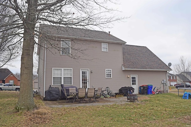 rear view of house with a lawn, a patio, and an outdoor fire pit