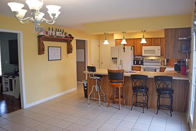 kitchen with stainless steel electric stove, a breakfast bar, pendant lighting, and refrigerator with ice dispenser