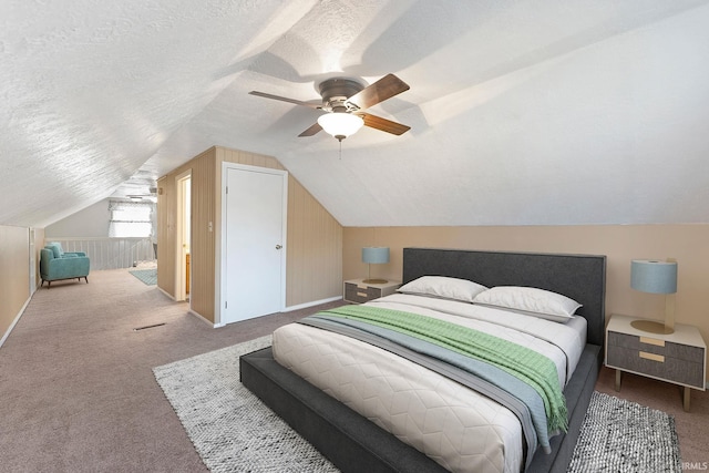 carpeted bedroom featuring ceiling fan, vaulted ceiling, and a textured ceiling