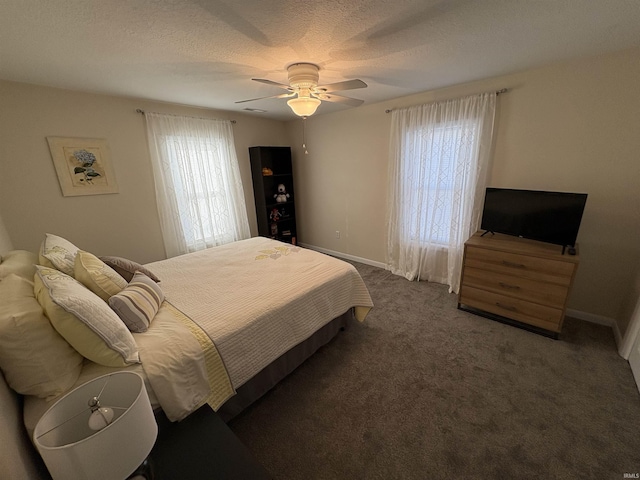 bedroom featuring dark colored carpet, ceiling fan, and a textured ceiling