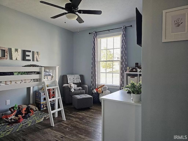 bedroom with ceiling fan, dark hardwood / wood-style flooring, and a textured ceiling