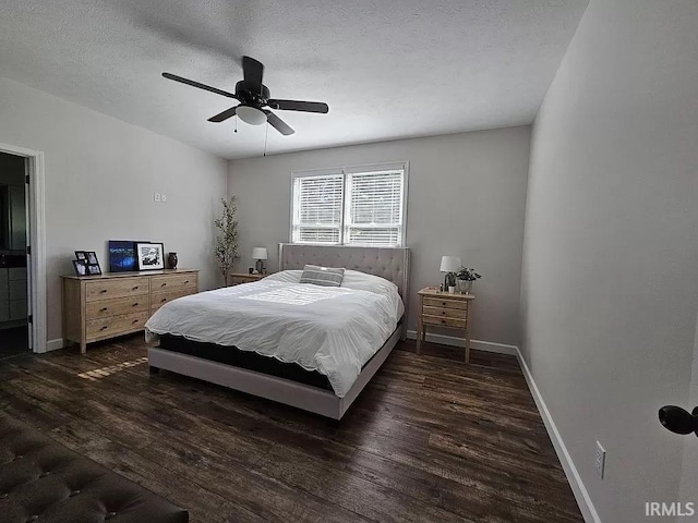 bedroom with ceiling fan, dark wood-type flooring, and a textured ceiling