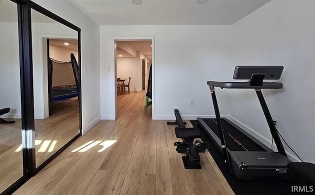 exercise room with light hardwood / wood-style flooring