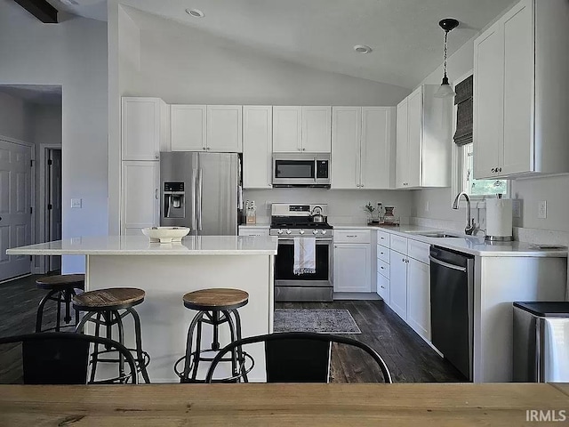 kitchen featuring sink, stainless steel appliances, a center island, and white cabinets