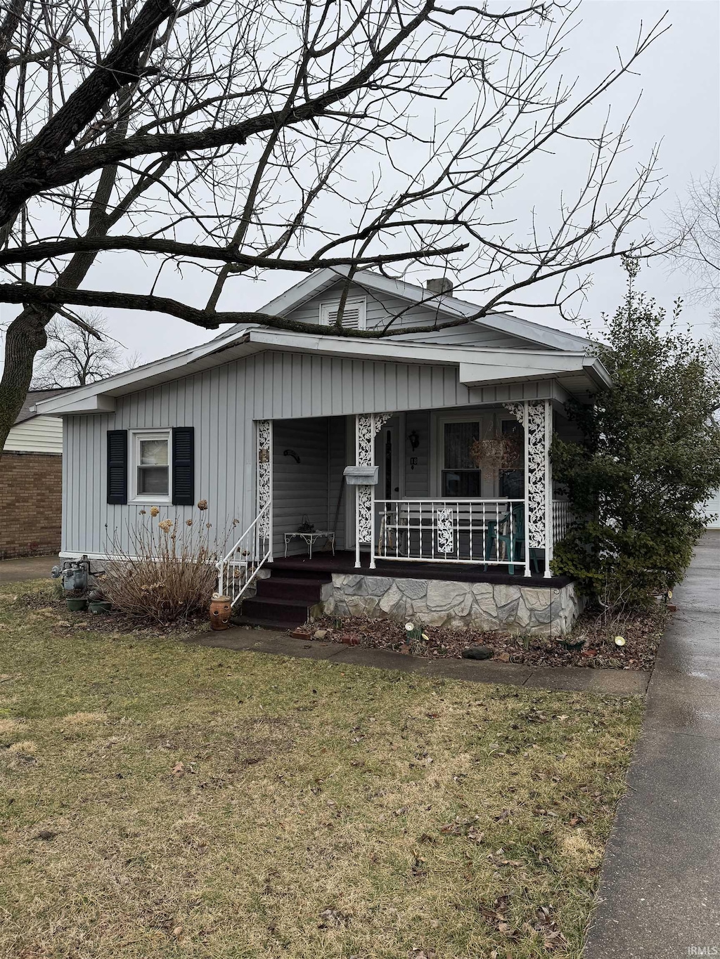 bungalow-style home featuring a front lawn and covered porch