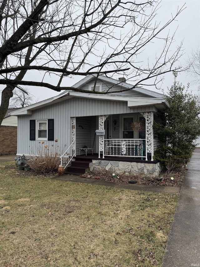 bungalow-style home featuring a front lawn and covered porch