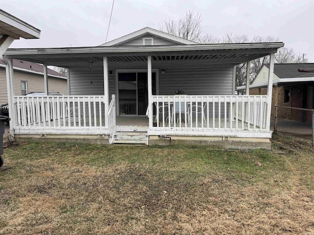 rear view of house with a yard and a porch