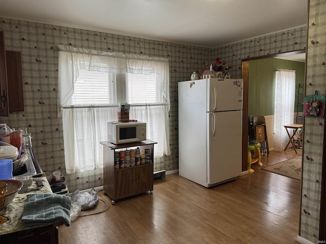 kitchen with hardwood / wood-style flooring and white appliances