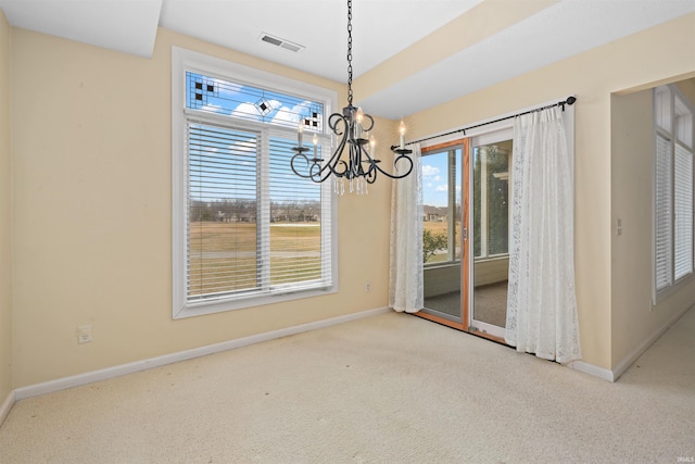 unfurnished dining area featuring an inviting chandelier and light colored carpet