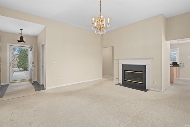 unfurnished living room with light colored carpet, a fireplace, and a notable chandelier