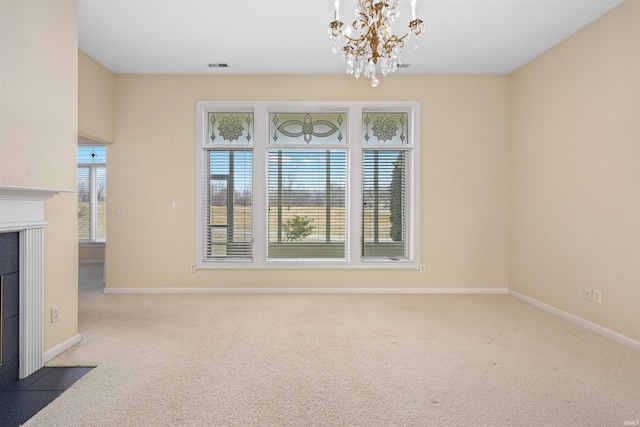 interior space featuring a tile fireplace, a chandelier, and carpet flooring