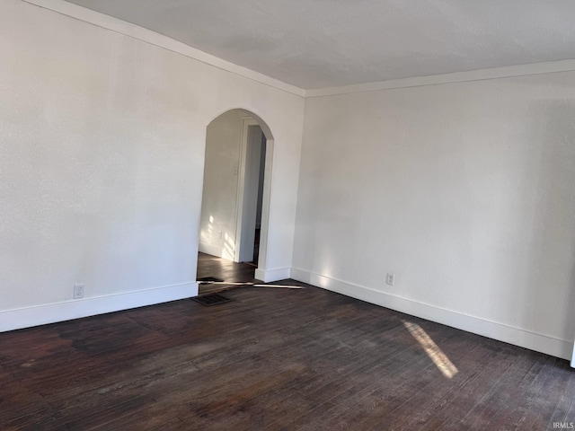605 W 10th St, Muncie, IN 47302 - empty room featuring crown molding and dark wood-type flooring
