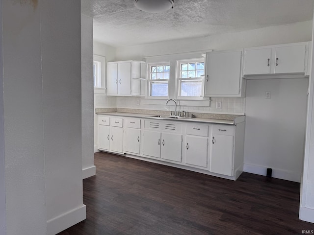 605 W 10th St, Muncie, IN 47302 - kitchen with sink, backsplash, a textured ceiling, white cabinets, and dark hardwood / wood-style flooring